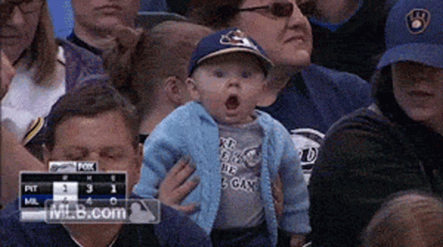 Baby in Blue Brewers Hat Held by Woman