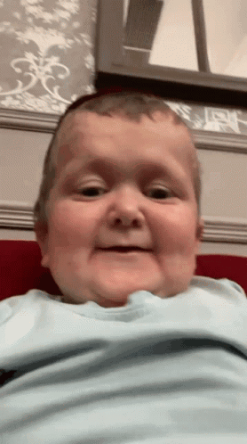 Baby In Blue Shirt Making Funny Face GIF