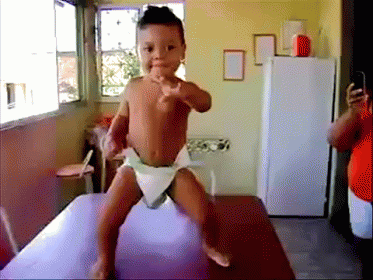 Baby in Diaper Pointing at Camera
