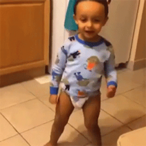 Baby in Diaper Standing on Tiled Floor