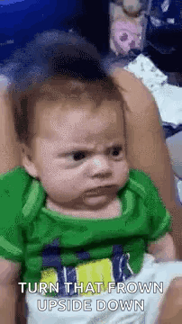 Baby in Green Shirt Making Funny Face