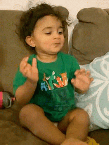 Baby In Green Shirt Making Funny Face GIF