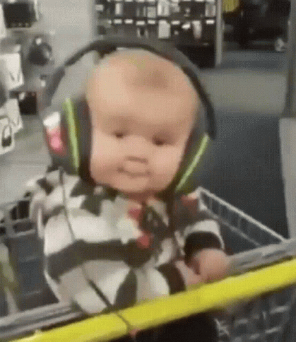 Baby In Headphones Sitting In Shopping Cart GIF