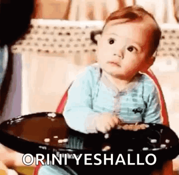 Baby in High Chair Holding Bowl of Food