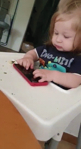 Baby in High Chair Playing With Phone Wearing No-Limit Shirt