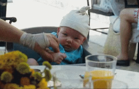 Baby In High Chair Wearing White Hat GIF
