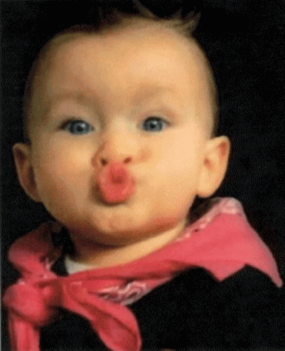 Baby in Pink Scarf Blowing a Kiss