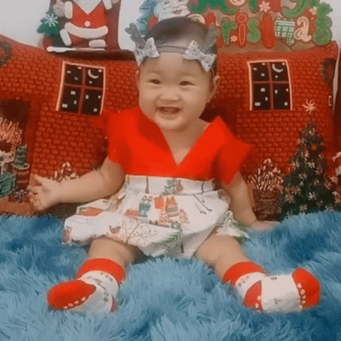 Baby in Red and White Dress on Blue Blanket