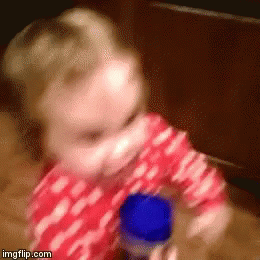 Baby in Red and White Polka Dot Shirt Playing with Blue Bottle