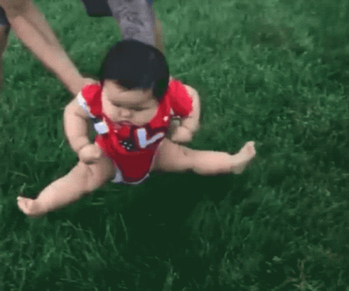 Baby in Red Bodysuit Being Held