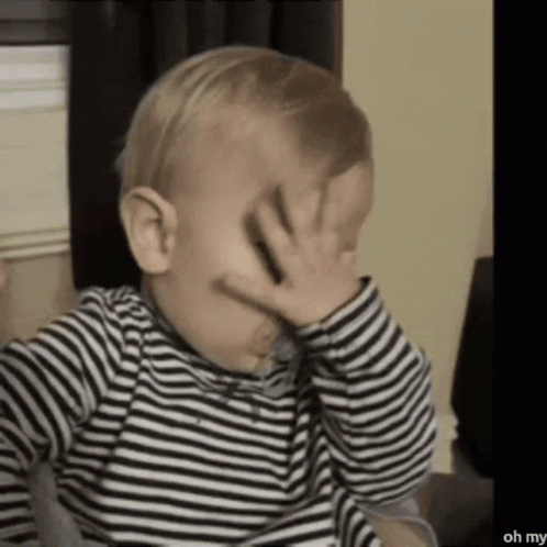 Baby in Striped Shirt Covering Face