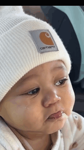 Baby in White Carhartt Beanie Looking at Camera