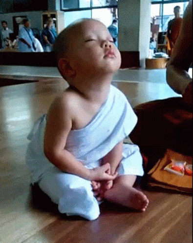 Baby in White Robe with Eyes Closed