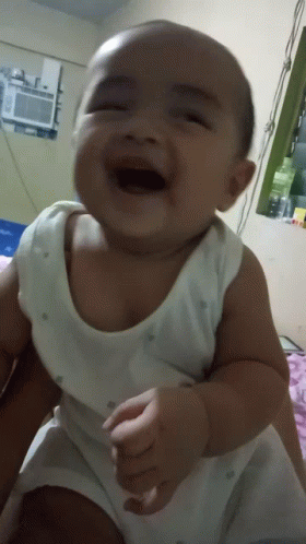 Baby in White Tank Top Laughing With Mouth Open
