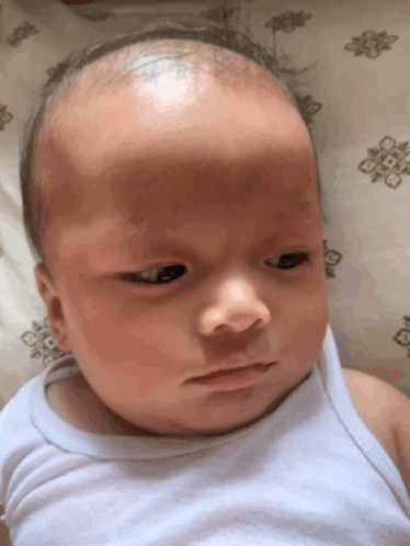 Baby in White Tank Top Lying on Bed