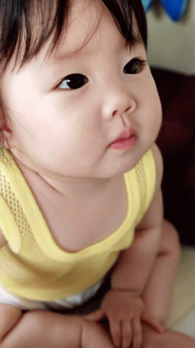 Baby in Yellow Tank Top Looking Up