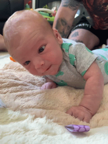 Baby Laying on Blanket in Dinosaur Shirt
