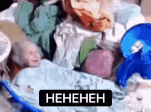 Baby Laying on Pile of Clothes with Heneheneh Sign