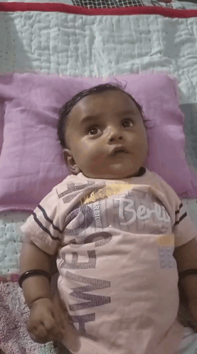 Baby Laying on Purple Pillow with Berry Shirt