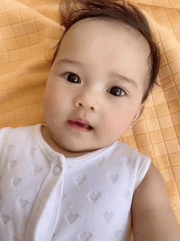 Baby Laying on Yellow Blanket Looking Up