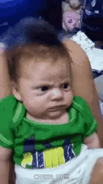 Baby Making Funny Face Held by Woman