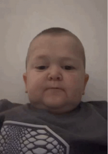 Baby Making Funny Face In Gray Shirt GIF