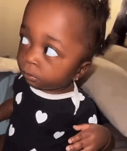Baby Making Funny Face In Heart Dress GIF