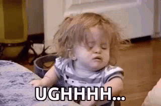 Baby On Couch With Messy Hair Making Face GIF