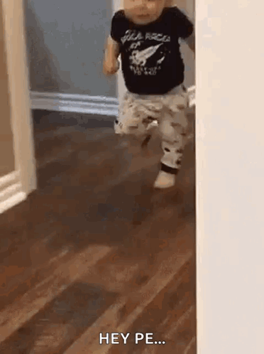Baby Running Through Doorway In Black Shirt And Pants GIF