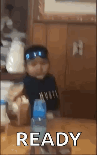 Baby Sitting at Table With Water Bottle