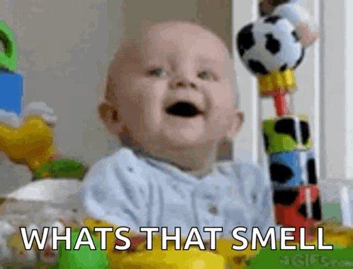 Baby Sitting in Crib With Toys and Whats That Smell