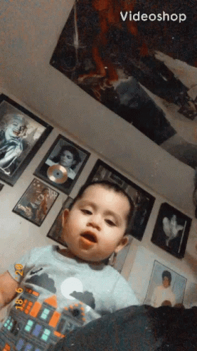 Baby Sitting in Front of Pictures and Videoshop Logo