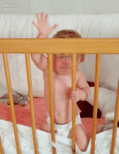 Baby Sitting In Wooden Crib Arms Outstretched GIF