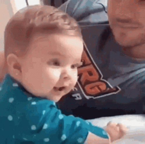 Baby Sitting Next to Man in Shirt
