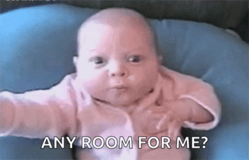Baby Sitting on Blue Pillow Saying Any Room For Me