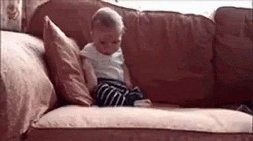 Baby Sitting on Couch with Pillow