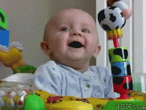 Baby Smiling in Crib with Toys