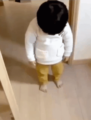 Baby Standing in Wooden Hallway