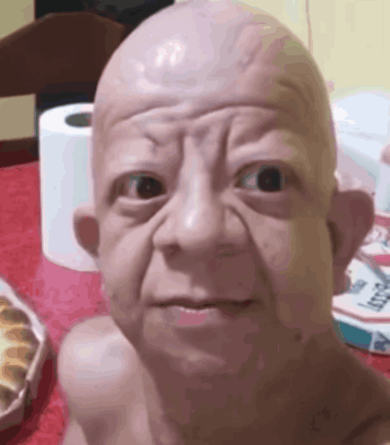 Baby Statue Sitting Next to Toilet Paper