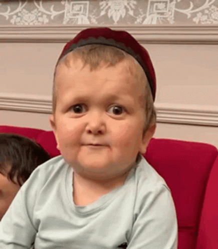 Baby With Headband Making Funny Face Red Couch