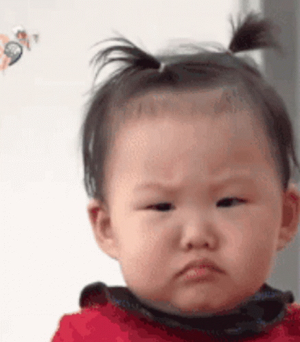 Baby With Ponytail Making Funny Face GIF