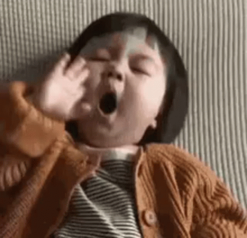 Baby Yawning on Bed in Sweater