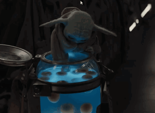Baby Yoda Sitting in Front of Blue Bowl
