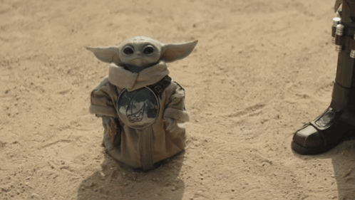 Baby Yoda Statue Sitting on Sand