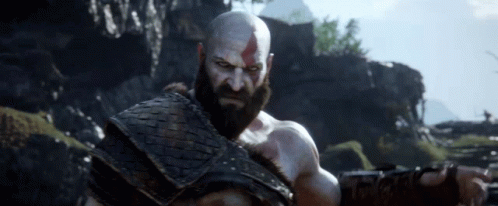 Bald Bearded Man in Field With Mountains