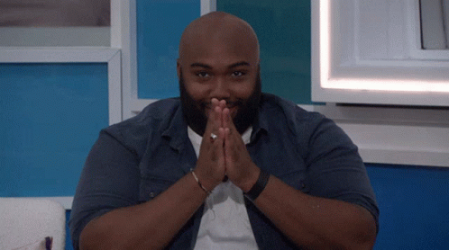 Bald Bearded Man Sitting with Folded Hands