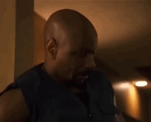 Bald Bearded Man Standing in Dark Room