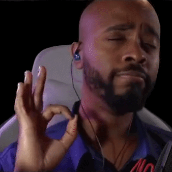 Bald Bearded Man with Ear Buds Making OK Sign