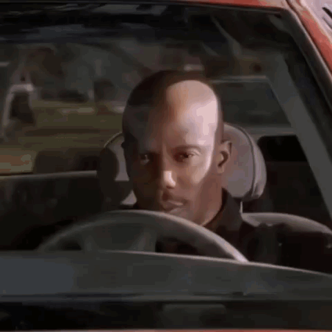 Bald Man Driving Looking at Camera