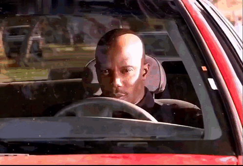 Bald Man Driving Red Car Looking Out Window